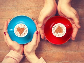 Women and man holding cups of coffee